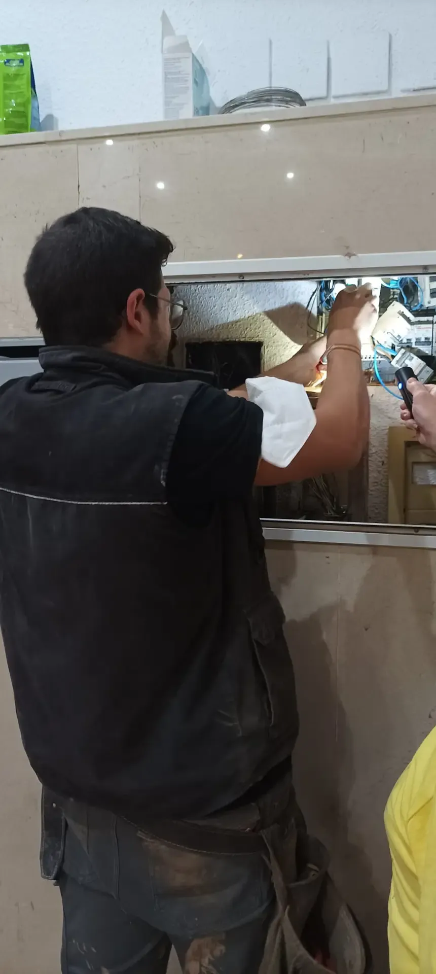 Aitor reparando una instalación desde una escalera
